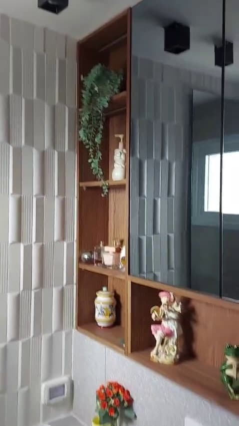 חיפוי קיר תלת-ממדי ונישת מדפי עץ בחדר רחצה משופץ