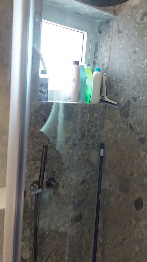 מקלחון עם חיפוי טראצו וחלון בתוך המקלחת