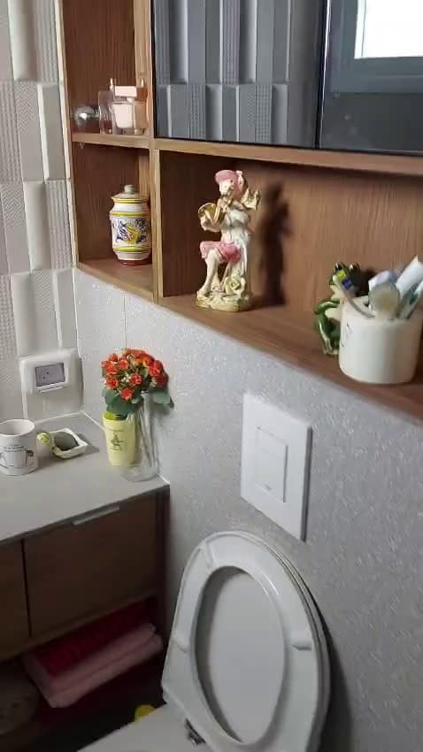 חדר שירותים משופץ עם מדפי עץ וחיפוי תלת-ממדי